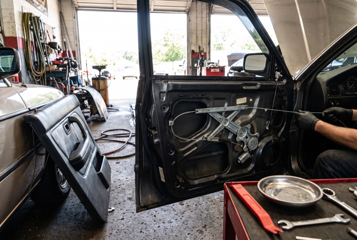 Car door with panel removed showing the window regulator mechanism during repair