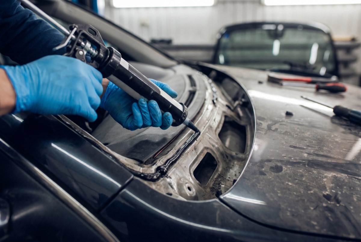 Technician applying urethane adhesive during a windshield replacement in Celina, TX